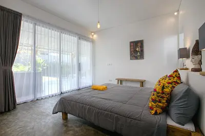 a bedroom with a bed and a large window at Villa Mertanadi - Cosy 2bdrs in center Kerobokan - popular district in Seminyak