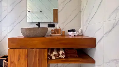 a bathroom with a wooden counter with a sink at Seminyak Loft 360 Private Pool Villas in Seminyak