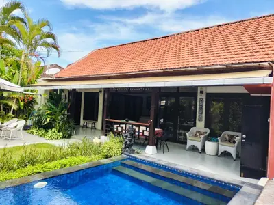 a house with a swimming pool in front of a house at Villa Casa Jamika in Seminyak