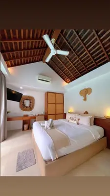 a bedroom with a large bed with a ceiling fan at Rove Pool Villa Seminyak in Seminyak