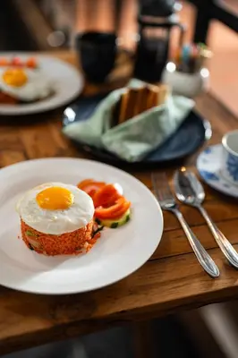 a plate of food with an egg on a table at The Casa Amaya By Puri Asia in Jimbaran
