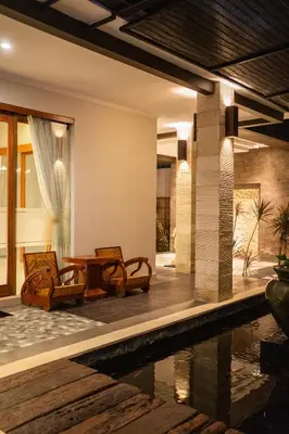 a resort with a pool and chairs and a house at The Casa Amaya By Puri Asia in Jimbaran