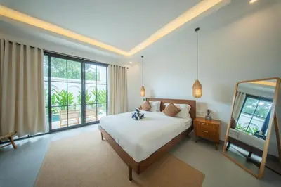 a bedroom with a bed and a large window at Modern and Quiet 2BR Villa in Seminyak Central with Private Pool in Denpasar