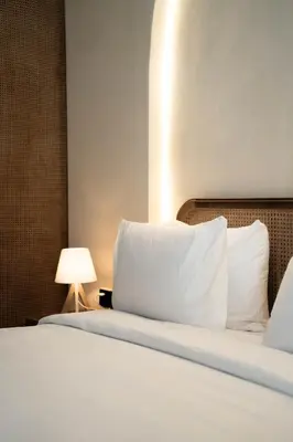 a bedroom with a bed with white pillows and a lamp at Villa Ocean Bali in Seminyak