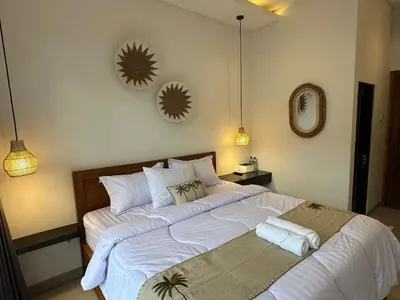 a bedroom with a large bed with two mirrors on the wall at bali thousand island living - guest house in Pesanggaran