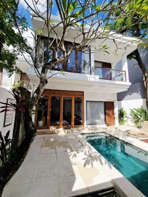 a house with a swimming pool in front of a house at Villa Wild in Seminyak