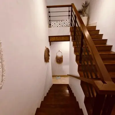 a staircase in a house with a wooden railing at Villa Wild in Seminyak
