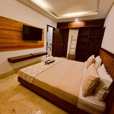 a bedroom with a large bed and a flat screen tv at Villa Wild in Seminyak