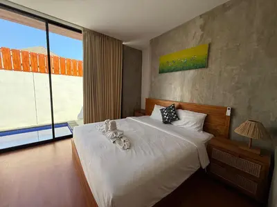 a bedroom with a bed and a large window at Ozzy Bali Villa 3 in Seminyak