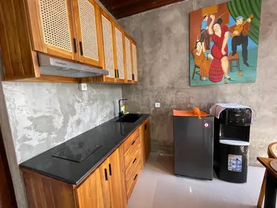 a kitchen with a black counter top and a refrigerator at Ozzy Bali Villa 3 in Seminyak
