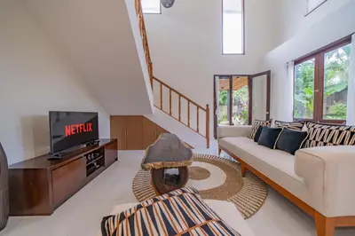 a living room with a couch and a tv at Adamo villa Seminyak in Seminyak