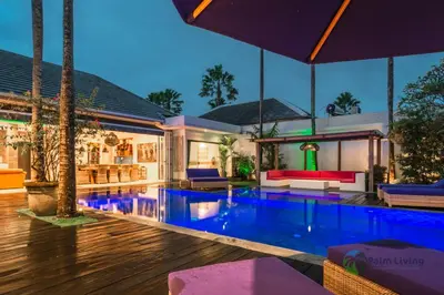 a house with a swimming pool at night at Villa Babar in Canggu