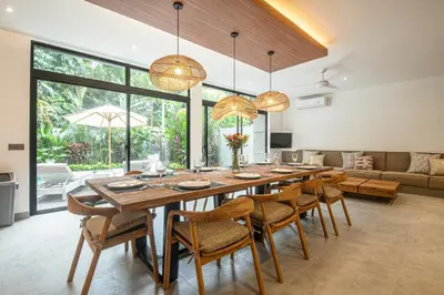 a dining room with a large wooden table and chairs at Stylish 5BR Designer Villa, 400m to the Ocean in Canggu