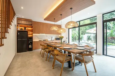 a dining room with a large wooden table and chairs at Stylish 5BR Designer Villa, 400m to the Ocean in Canggu