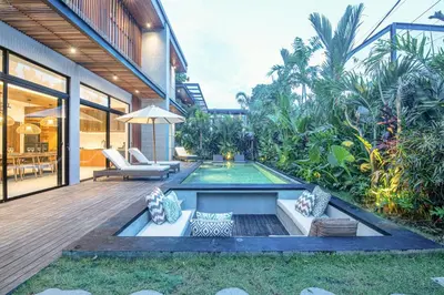 a backyard with a swimming pool and a house at Elegant 5BR Modern Villa Steps from Café Del Mar in Canggu
