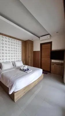 a bedroom with a large white bed and a piano at NOWACs SASADARA in Canggu