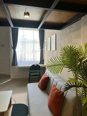 a living room with a couch and a plant at De Kamar Mezzanine in Denpasar