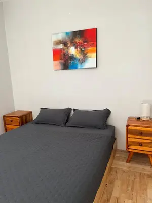 a bedroom with a bed and a painting on the wall at Persada Loft Bali in Seminyak