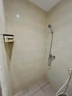 a shower in a bathroom with a tile wall at Persada Loft Bali in Seminyak