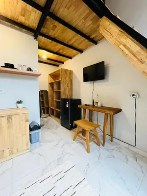 a room with a table and a tv on a wall at Persada Loft Bali in Seminyak