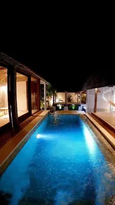 a large swimming pool with blue water at night at PROMO Private Vacation Rental Villa 2 Pools 4 Bedrooms 4 Bathroom Free Airport Pickup in Denpasar