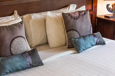 a bed with four pillows on top of it at Villa Sedap Malam Seminyak by Best Deals Asia Hospitality in Seminyak