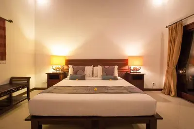 a bedroom with a large bed with two lamps at Villa Sedap Malam Seminyak by Best Deals Asia Hospitality in Seminyak