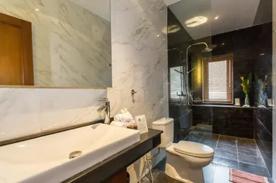 a bathroom with a tub and a toilet and a sink at Villa Balidamai in Kerobokan