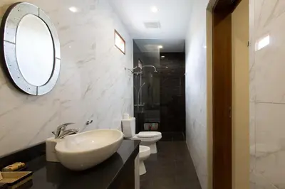 a bathroom with a sink and a toilet and a mirror at Villa Balidamai in Kerobokan