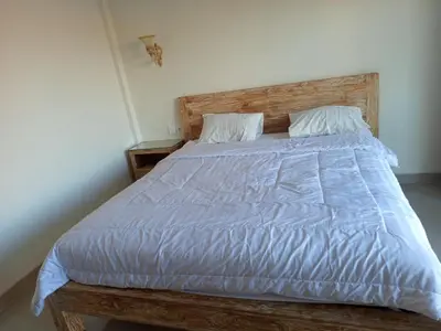 a bed with a blue comforter and two pillows at Erick house in Seminyak