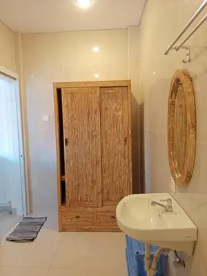 a bathroom with a wooden door and a sink at Erick house in Seminyak