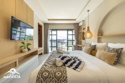 a bedroom with a large bed and a tv at Serayu Berawa by Bukit Vista in Canggu