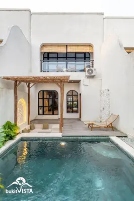 a villa with a swimming pool and a house at Serayu Berawa by Bukit Vista in Canggu