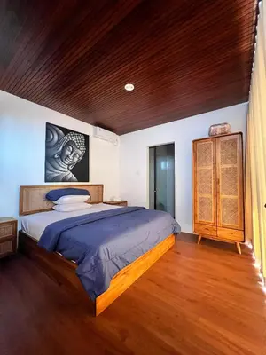 a bedroom with a large bed and a wooden ceiling at Oemah Ozzy Villa 2 Bedroom With Privat Pool in Seminyak