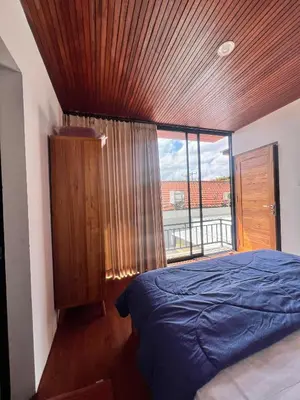 a bedroom with a bed and a large window at Oemah Ozzy Villa 2 Bedroom With Privat Pool in Seminyak