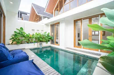 an indoor pool in a house with a blue couch at NEW! Spring Villa - 2BR Villa in Kerobokan in Kerobokan