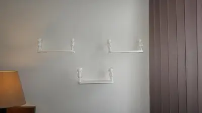 a white wall with three empty shelves on it at Ambengan Tenten By BMI in Denpasar