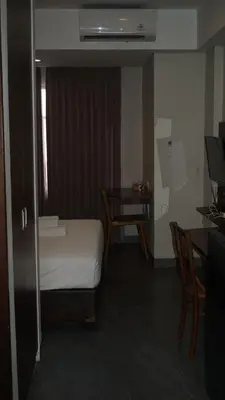 a room with a bed and a desk and a table at Ambengan Tenten By BMI in Denpasar