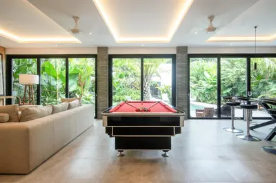 a pool table in a living room with a couch at Luxury 3BR Modern Villa in the Heart of Seminyak in Seminyak