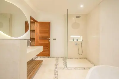 a bathroom with a shower and a sink and a mirror at Luxury 3BR Modern Villa in the Heart of Seminyak in Seminyak