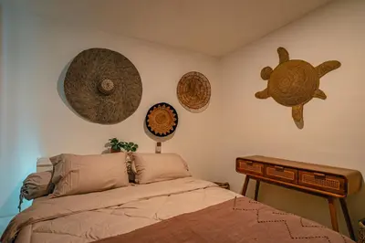 a bedroom with a bed and some hats on the wall at Amshiga 6 in Jimbaran