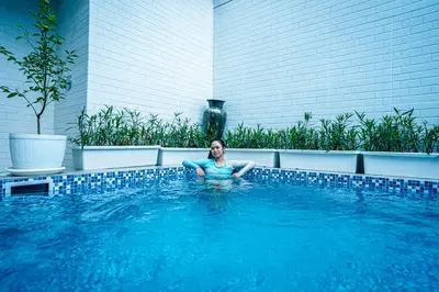 a woman is sitting in a swimming pool at Amshiga 6 in Jimbaran