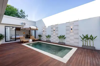 a swimming pool in the middle of a house at Nirvana Villa by Betterplace in Seminyak