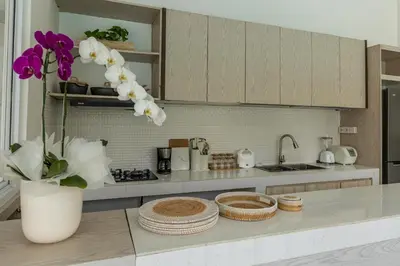 a kitchen with a vase of flowers on a counter at Soma Villa by Betterplace in Jimbaran