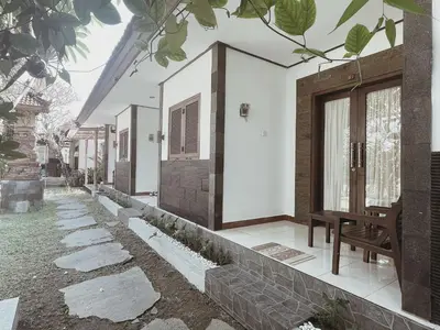 a row of houses with a bench on a sidewalk at Kubu Van Helen in Legian