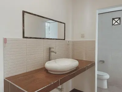 a bathroom with a sink and a mirror on a counter at Kubu Van Helen in Legian