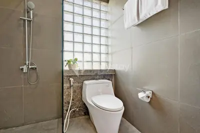 a bathroom with a white toilet and a shower at Gracia Villa by Kozystay - Jimbaran in Jimbaran