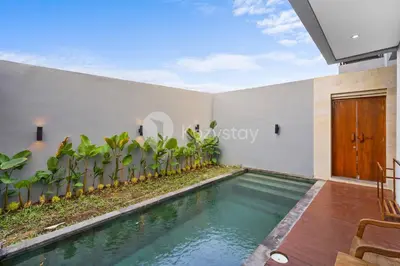a swimming pool in a villa with a house at Gracia Villa by Kozystay - Jimbaran in Jimbaran