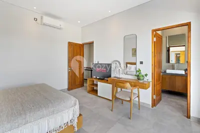 a bedroom with a bed and a desk and a sink at Gracia Villa by Kozystay - Jimbaran in Jimbaran