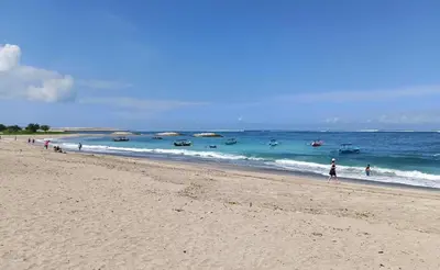 a group of people walking on a beach at ABI Hotel2 - 1 minute to the Beach and 1 second to the Mall in Ngurah Rai International Airport